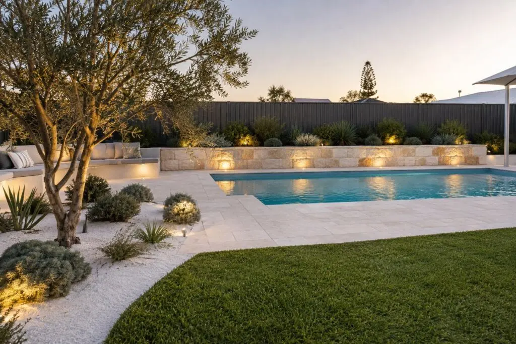 New pool surrounded by travertine paving and a limestone feature wall in a Scarborough coastal garden